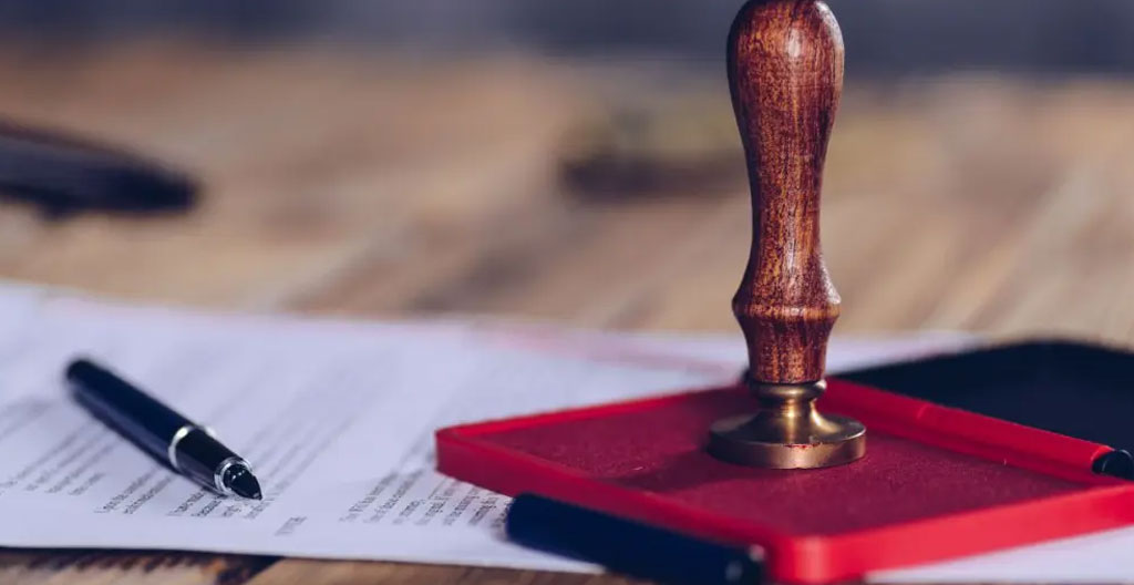 Gros plan sur les mains d'un notaire français montrant un document de bail emphytéotique lors d'un accompagnement juridique